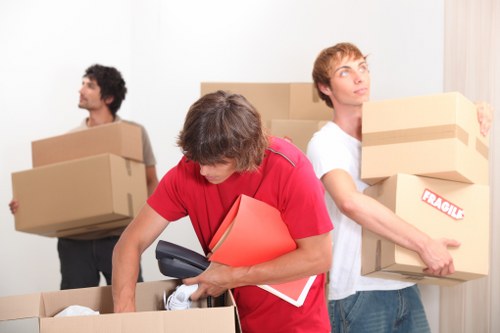 Movers handling a residential move in Leamouth near modern apartment buildings