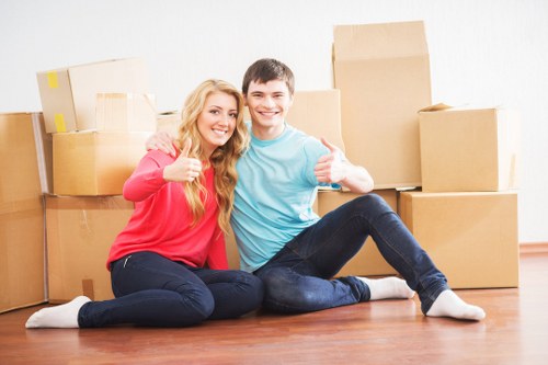 Local movers transporting furniture through an East London residential area