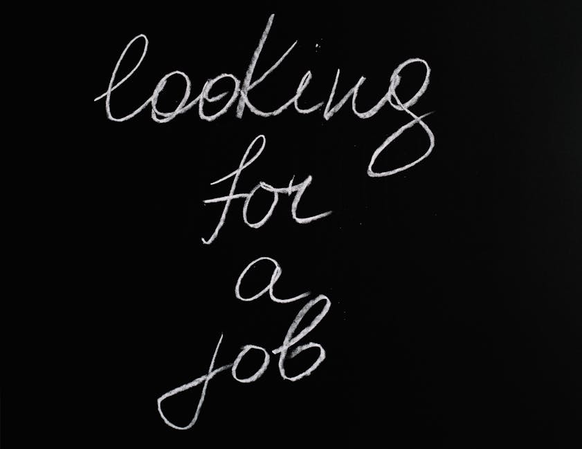 A close-up photograph showing a black background with white handwritten text reading 'looking for a job' in cursive style. The text appears to be written with a white pen or chalk, and the lighting is focused on the message, making the words clearly visible against the dark surface. The image does not include any objects, furniture, or physical elements related to house removals or moving services, but it can be associated with job searching or recruitment contexts connected to relocation services. Man with Van Leamouth, a professional removals company, is not depicted but is referenced as related to the webpage discussing pricing and moving logistics. The image's focus is solely on the handwritten message, with no additional contextual details or environmental features present.